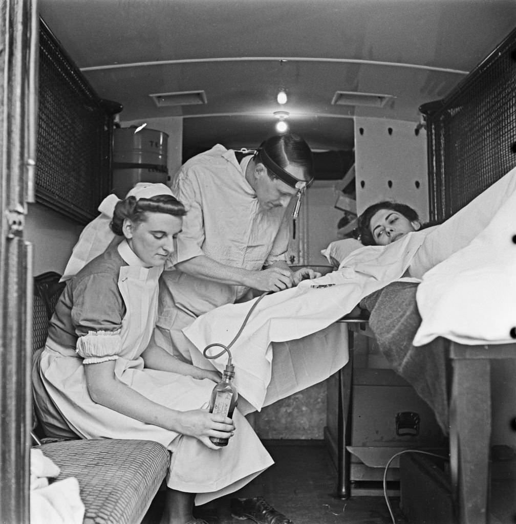 Nurse Marjorie Harrison and Doctor W Stanbury administer a transfusion of blood to a patient lying in an ambulance Great Britain vehicle following a German Luftwaffe air raid over the city of Ripon in Yorkshire.