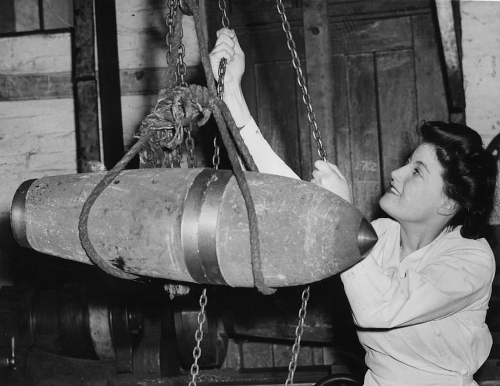 Once a waitress, Lilian Nye now works at a bomb factory in a disused church in Banbury, Oxfordshire, and is hauling a 500lb bomb on a winch, 4th April 1941.