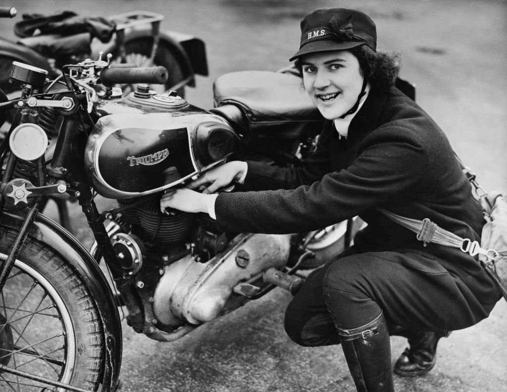 June Barrington-Ward a despatch riders for the Women's Royal Naval Service (WRNS) carries out maintenance on her Triumph 350CC 3SW motorcycles at WRNS London Headquarters on 11th March 1941.