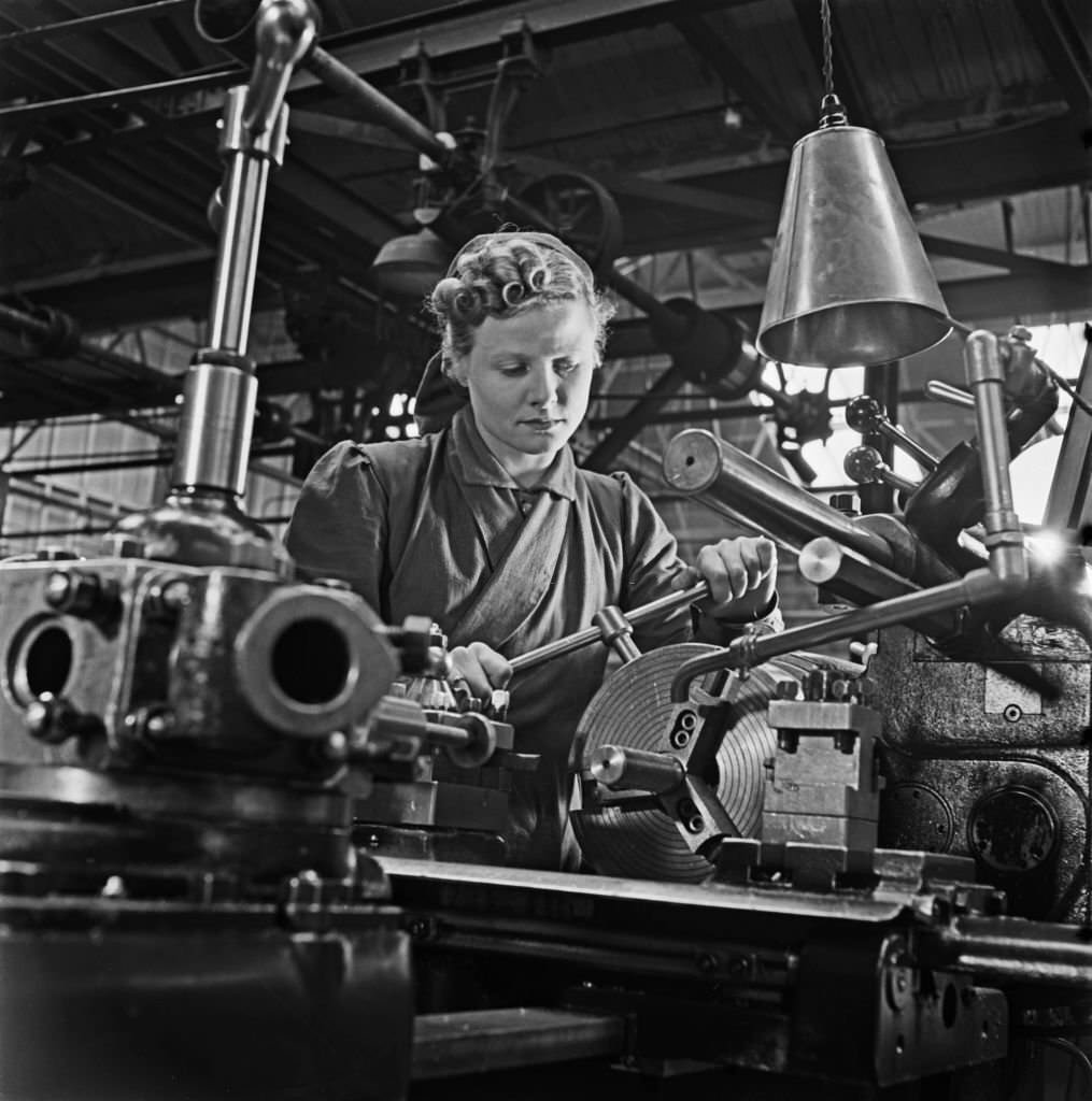 Trainee munitions worker Muriel Maggs, a former cinema usherette, operates a capstan lathe at a British Government training centre in Reading, England, 31st March 1941.