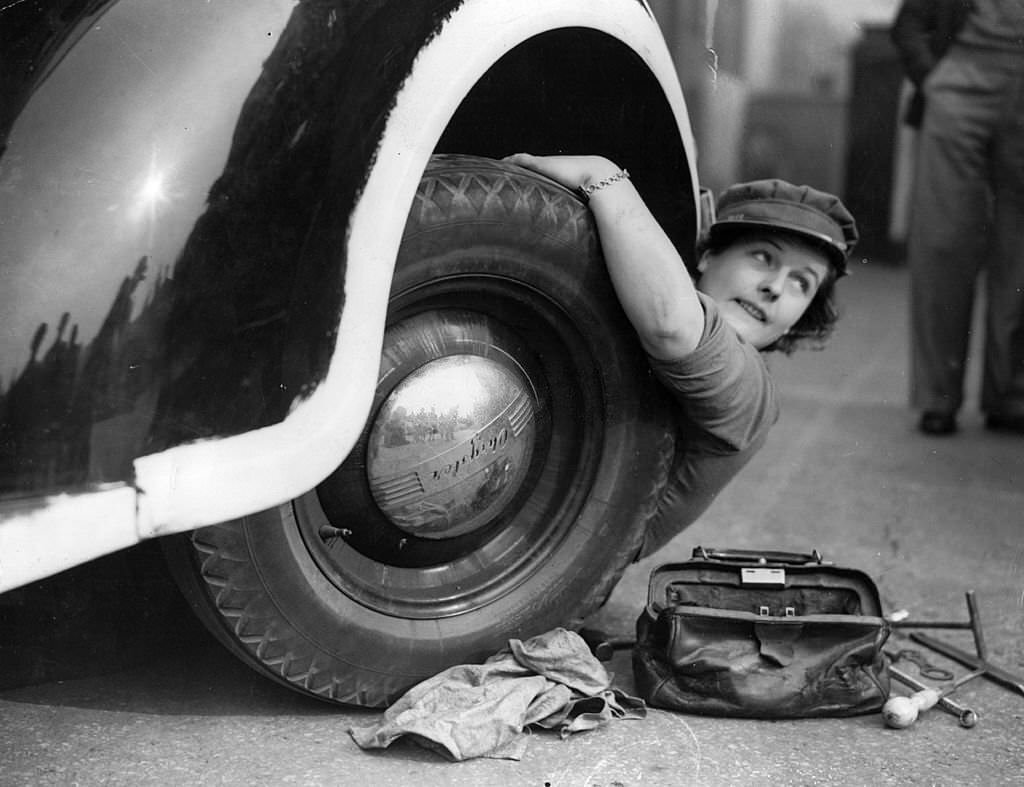 A member of the Mechanised Transport Training Corps changes a wheel at an ARP post in Lambeth, south London.