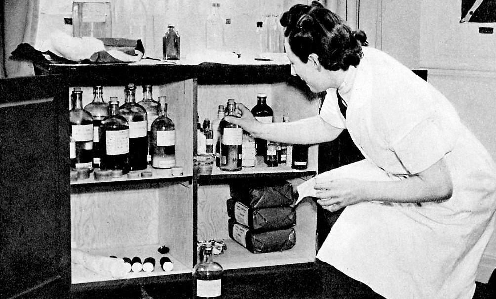 Women's Auxiliary Air Force (WAAF) - A nurse takes a bottle from a medicine cabinet.