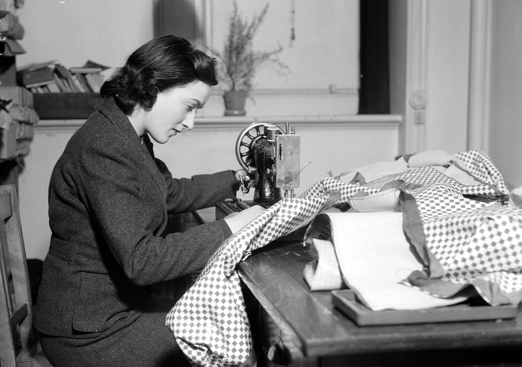 Lady Reading using a sewing machine at the Women's Voluntary Services headquarters during world War II.