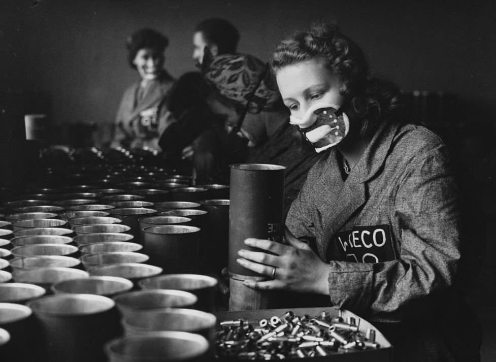 A woman factory worker makes canisters filled with smoke known as the "Wessex" Daylight Smoke Signals for use as distress flares on ships, 1941.