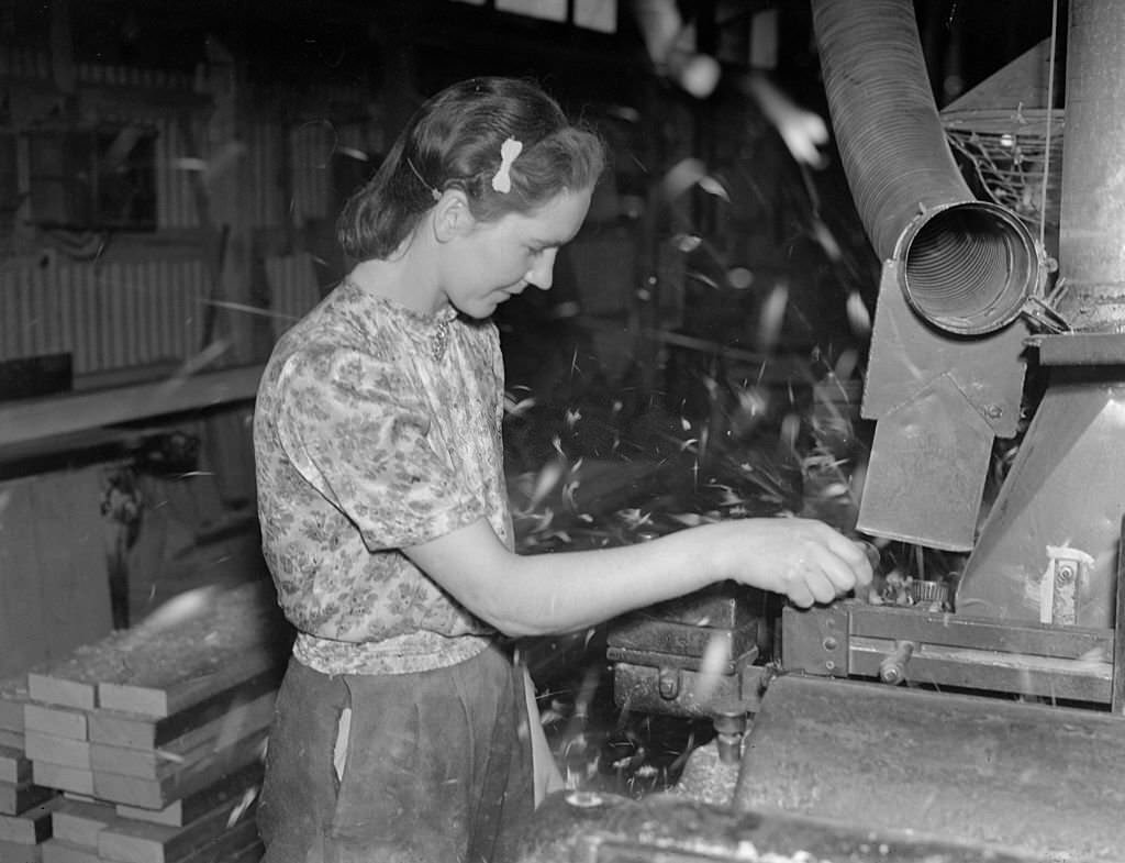 A woman war worker operating industrial machinery, 1941
