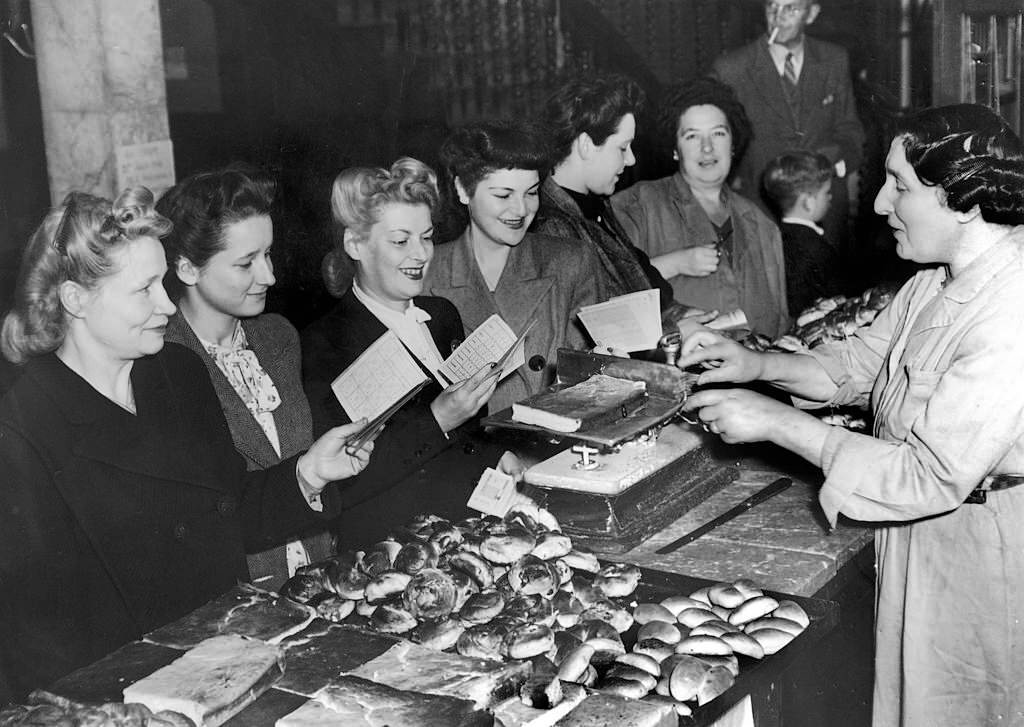 London Women With Their Notebooks, on which are listed and deducted their Food Rations, in a Bakery on Petticoat Lane On July 21, 1946.