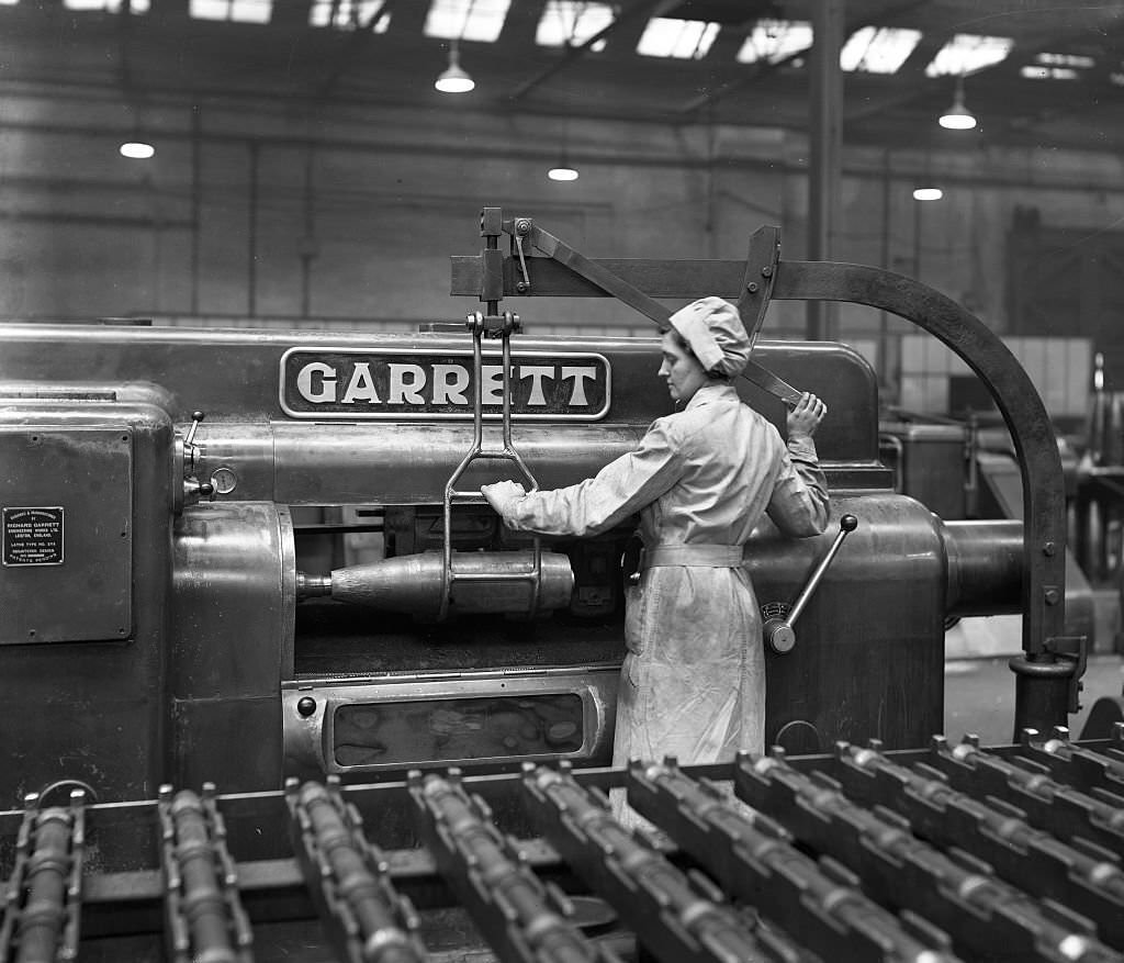 female employee loading a 6in. shell onto the finish turning machine