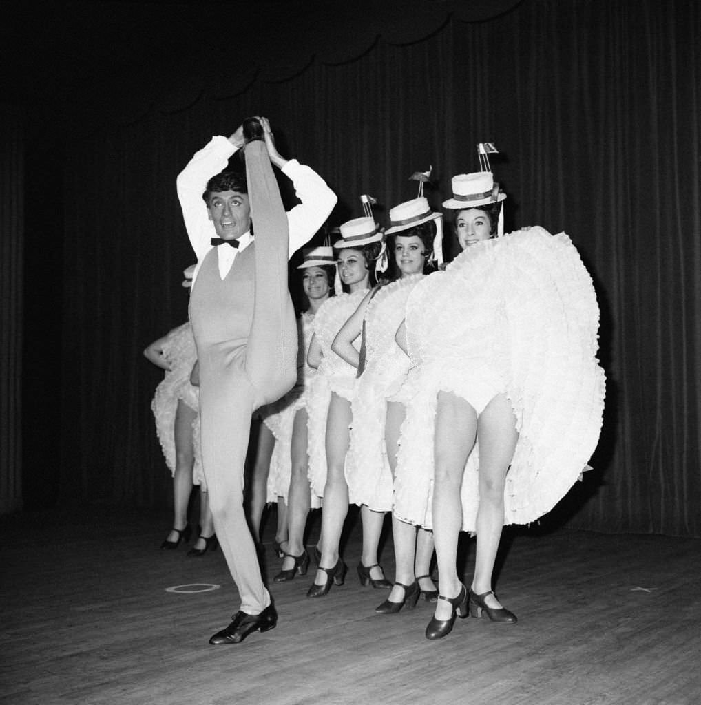 Star dancer Jean-Pierre Charnas during his number with the cancan dancers in the new revue 'Frou-frou' at the Moulin Rouge, in Paris, 1964