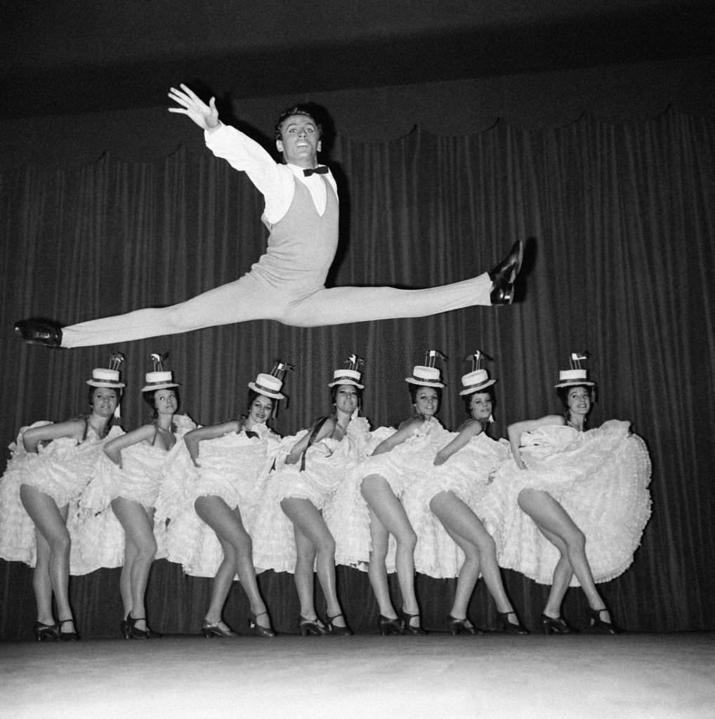 Star dancer Jean-Pierre Charnas during his number with the cancan dancers in the new revue 'Frou-frou' at the Moulin Rouge, 1964