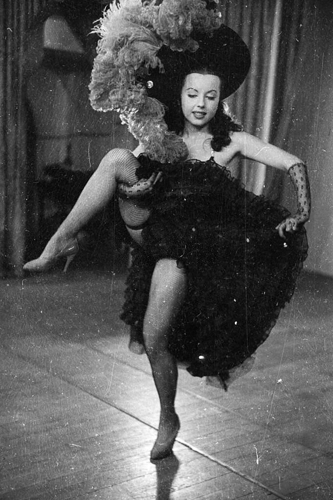 The chorus line at the Folies Bergere performing high kicks while dancing to 'Gaite Parisienne', 1955.