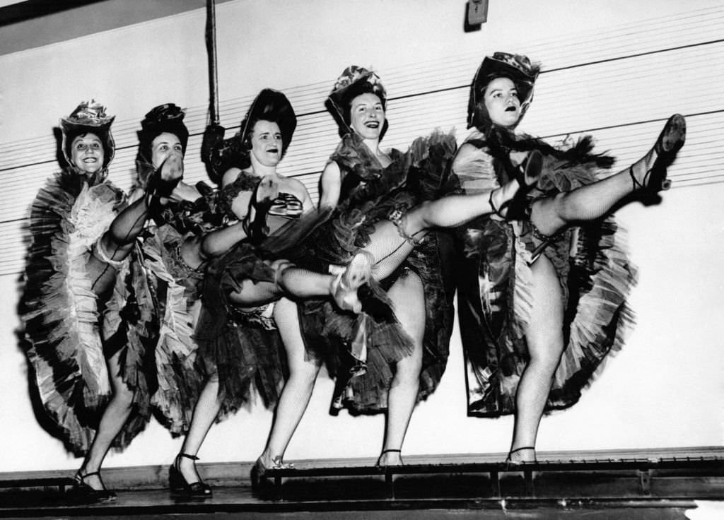 New York policewomen dance the French Can-can at the arrest line for suspects on May 18, 1953