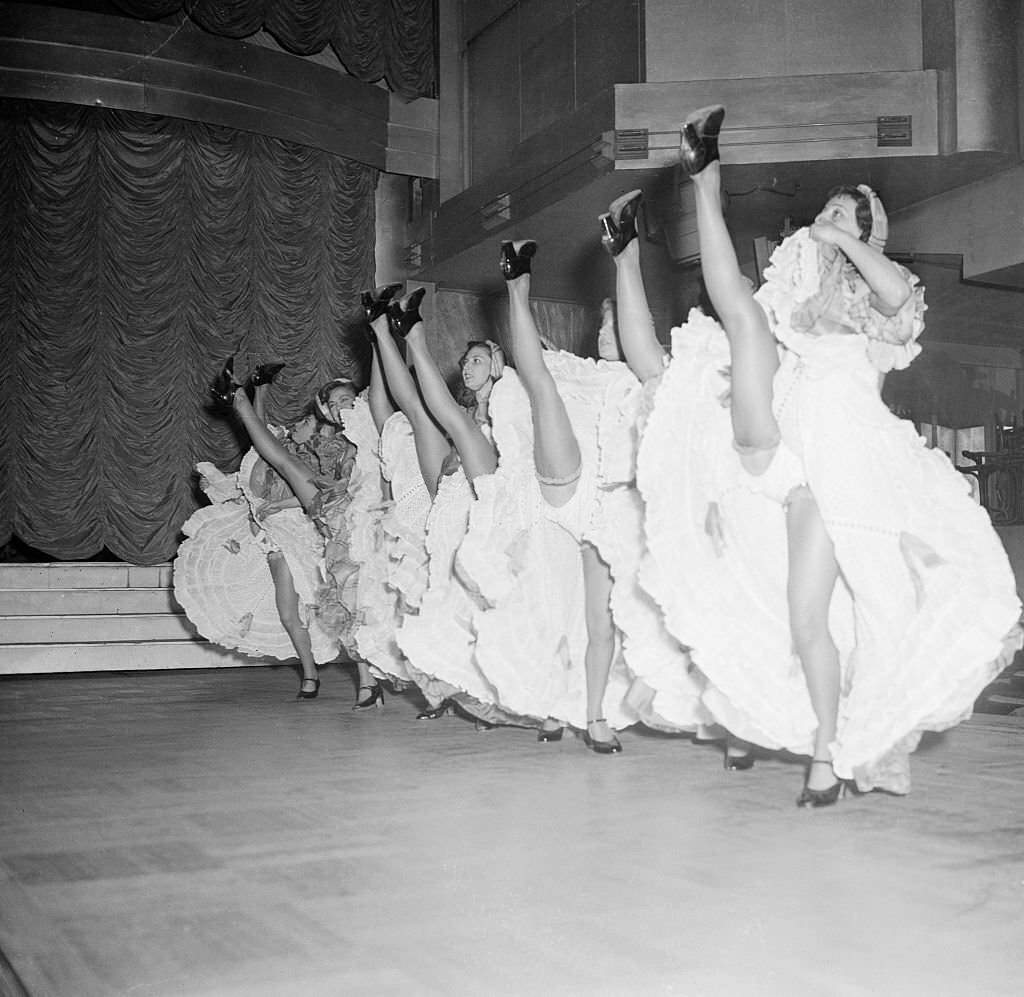 A chorus of high-kicking Cancan dancers go through their paces in preparation for the reopening, of the Parisian Music Hall Tabarin.