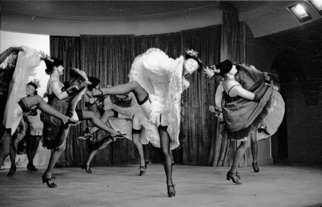 A troupe of can-can dancers leave little to the imagination during a performance of 'The Blue Bird', a cabaret show at London's Pigalle restaurant celebrating the coronation year of Queen Elizabeth II, 1953.