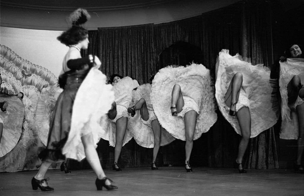 A troupe of can-can dancers leave little to the imagination during a performance of 'The Blue Bird', 1953