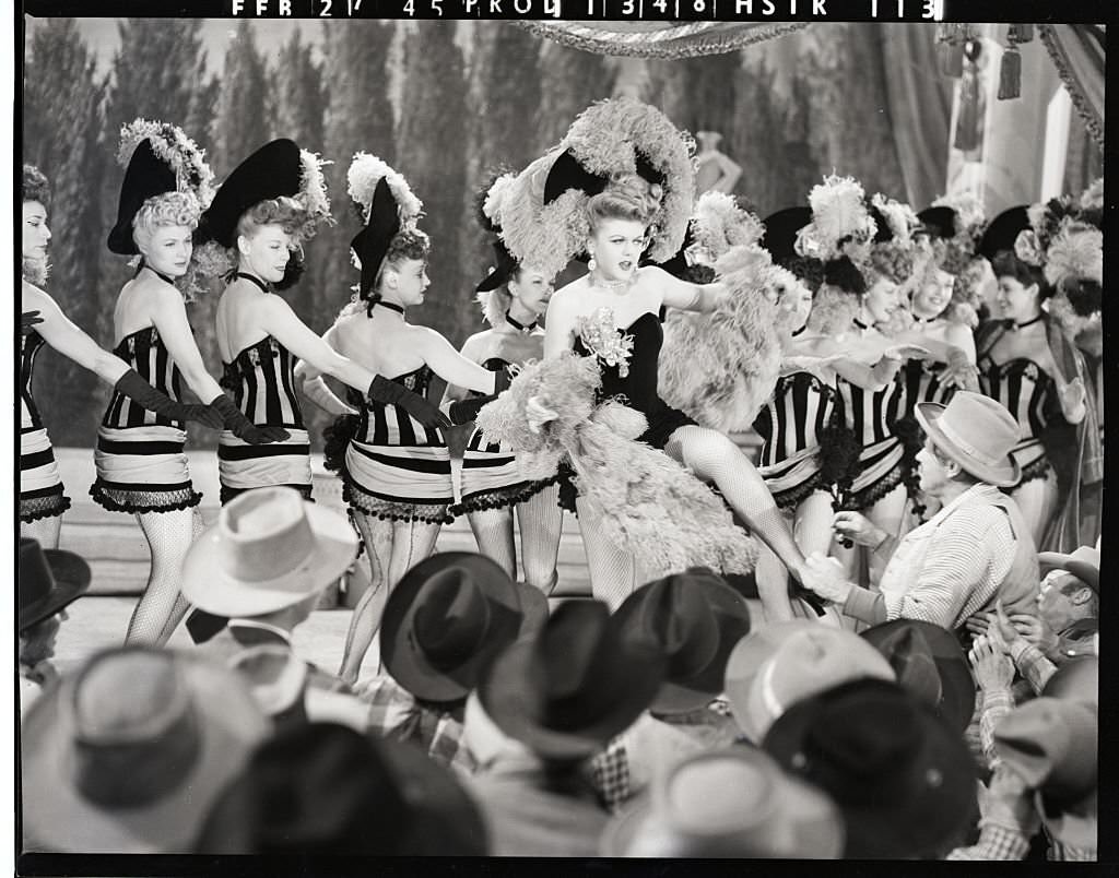 Ladies of the Chorus: Angela Lansbury, who portrays em, a dance hall queen, in MGM'S musical "The Harvey Girls," puts her all into her work as she leads the chorus in an old-fashioned "can-can."