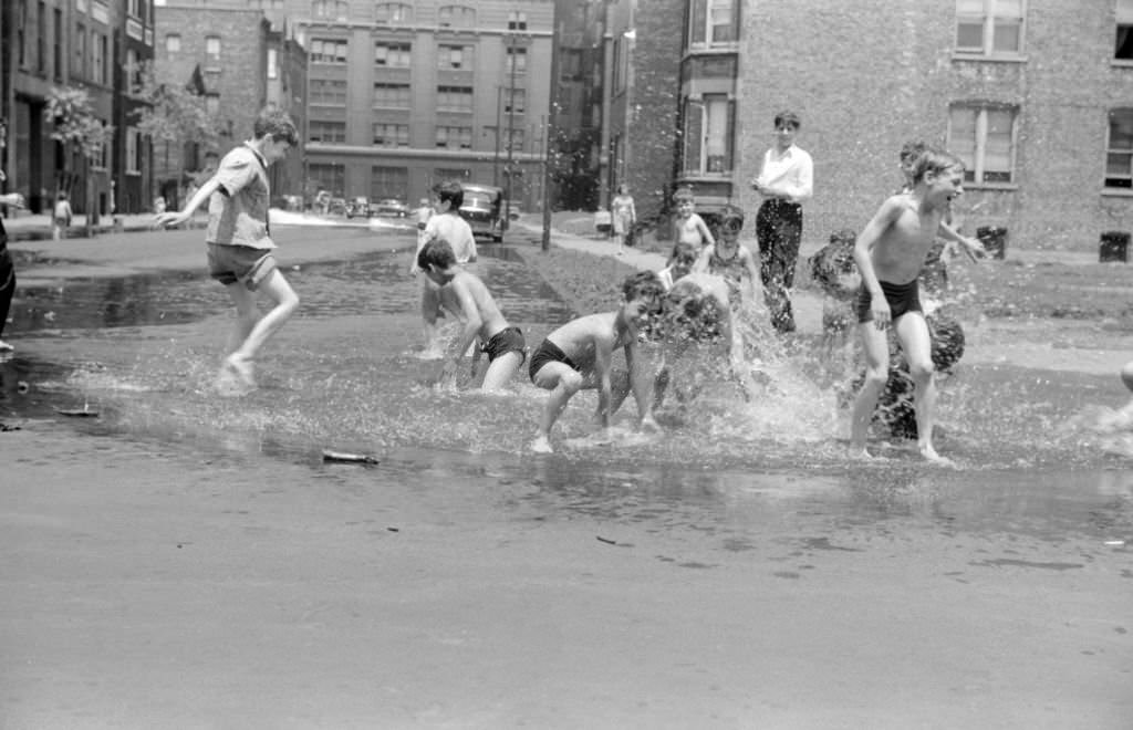 Children in a street are cooling off in water from hydrant, Chicago, Illinois, 1941.