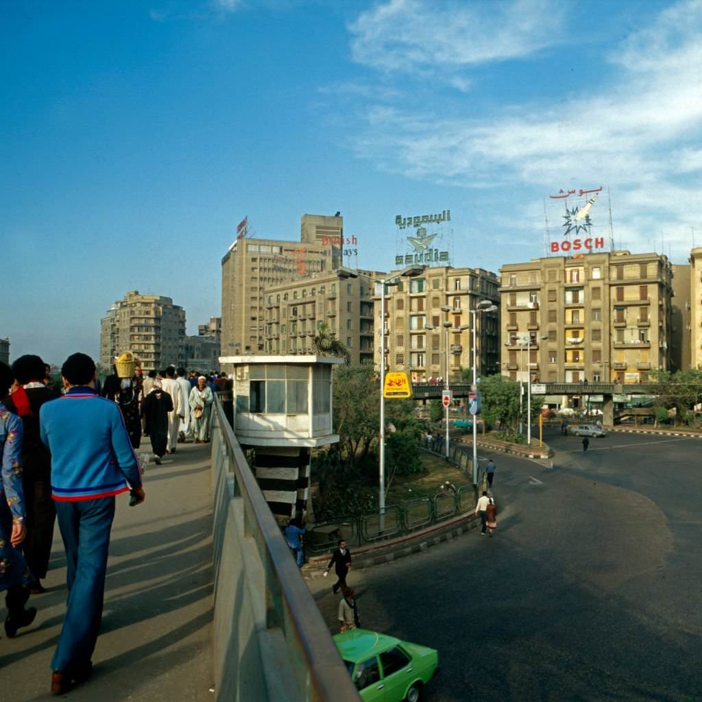 Passers by crossing a pavement bridge at Midan al Tahrir square, Cairo, Egypt, late 1970s.