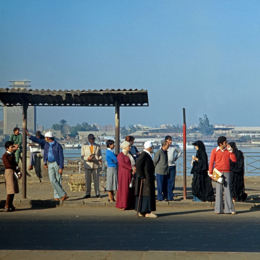 Cairenes waiting at a bus stop in the city of Cairo, Egypt, late 1970s.