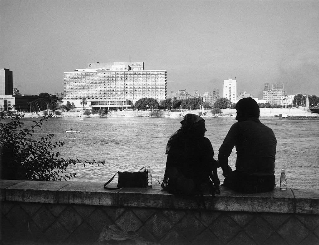 Couple at the riverbank of the Nile, in background the Hilton hotel, 1970
