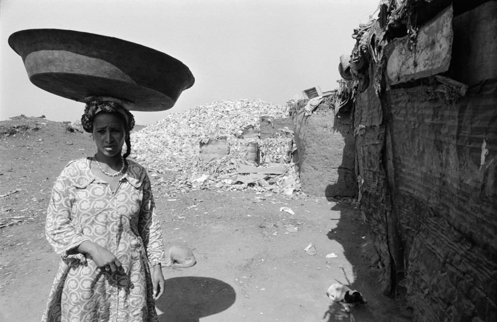 Young woman carrying a tray on her head in a slum on the outskirts of Cairo in October 1978, Egypt.