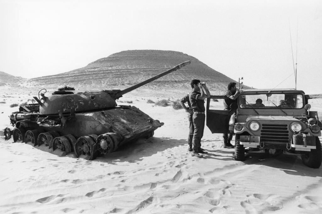 An Israeli tank exercise next to an Egyptian tank destroyed in June 1967 in the Sinai desert, 1978