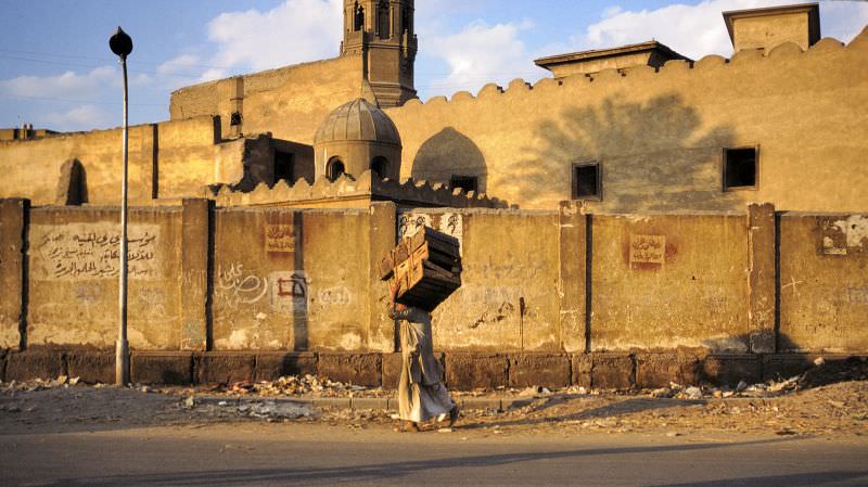 Cairo back street with porter and mosque, Egypt