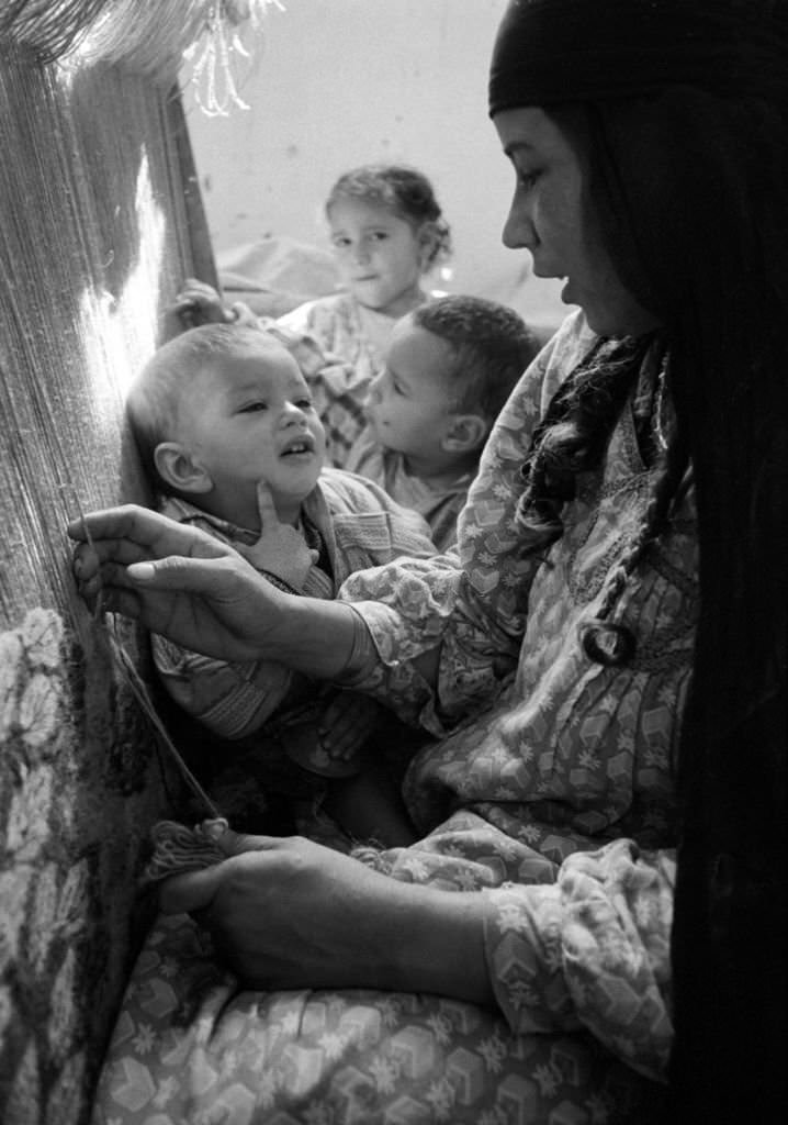 A carpet weaver with her children at work in a village near Cairo, 1972