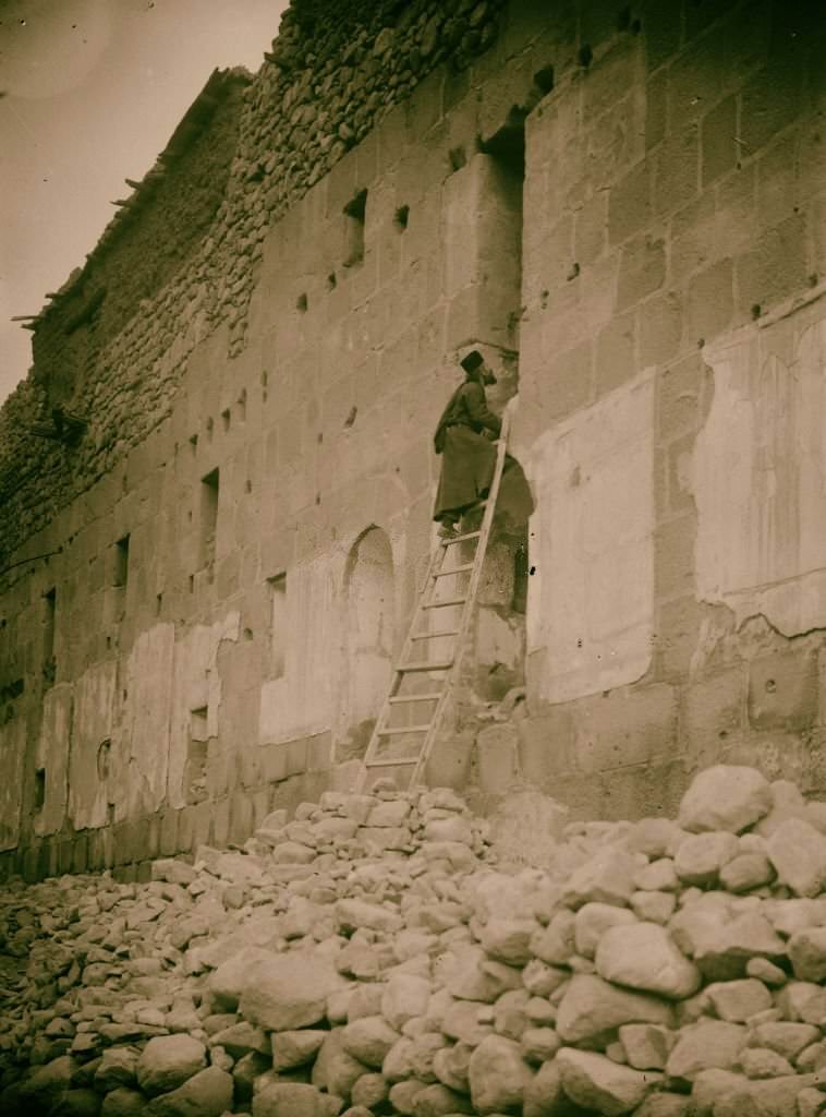 Sinai via the Red Sea, Tor, and Wady Hebran. Monk climbing up to his cell-chapel [Monastery of St. Catherine] in Sinai, Egypt, 1900