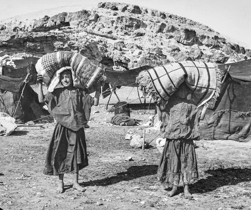 An expidition in Cairo boys carrying their beds from base camp, 1900