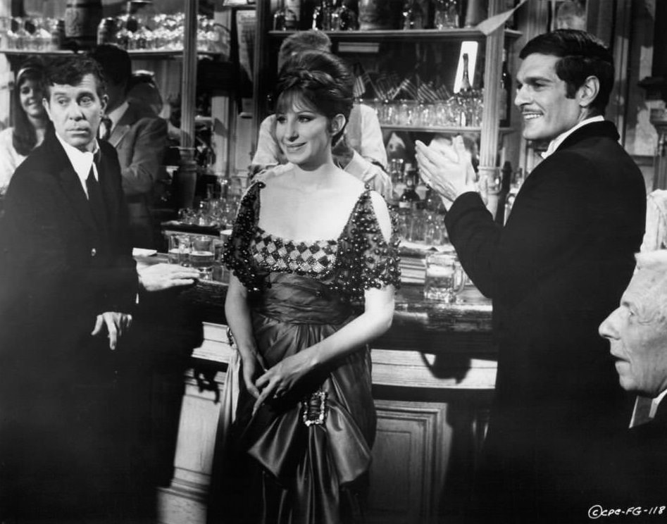 Lee Allen, Barbra Streisand, and Omar Sharif stand at a bar in a scene from the film 'Funny Girl', 1968.