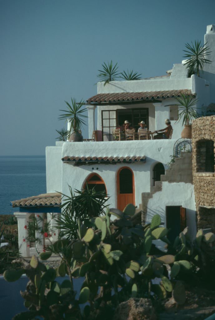 Residents on the balcony of a villa on the bay of Cala Xarraca, near Portinatx, Ibiza, Spain, 1978.