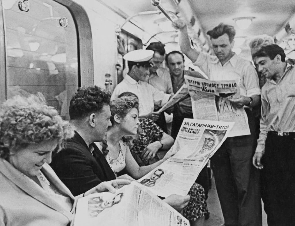 Commuters in a carriage, some reading newspapers reports about Soviet cosmonaut Gherman Titov (1935-2000) who had become only the second human to orbit the Earth, 1960