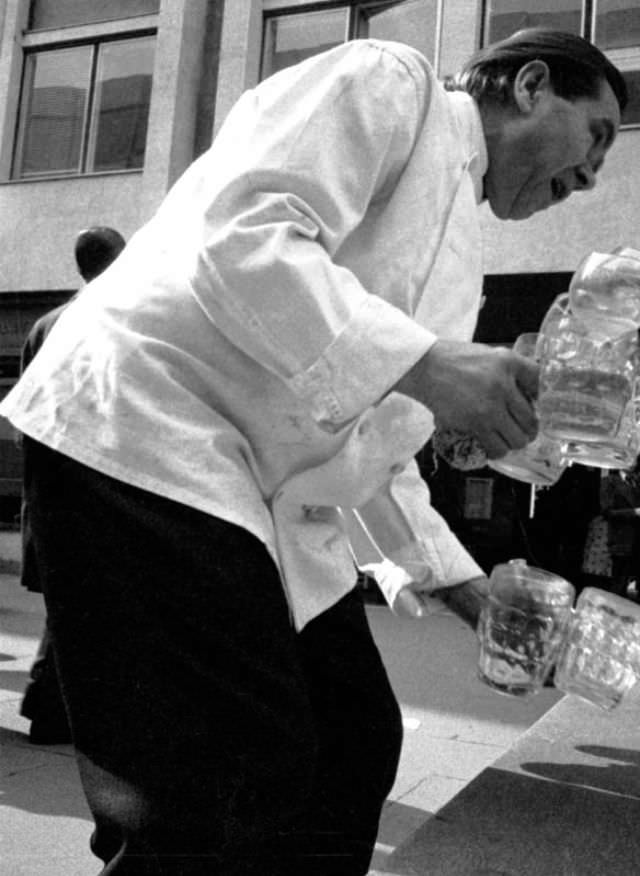 Potman from the Sir Christopher Wren pub collects beer mugs from the seating near St Paul's, London, April 1973