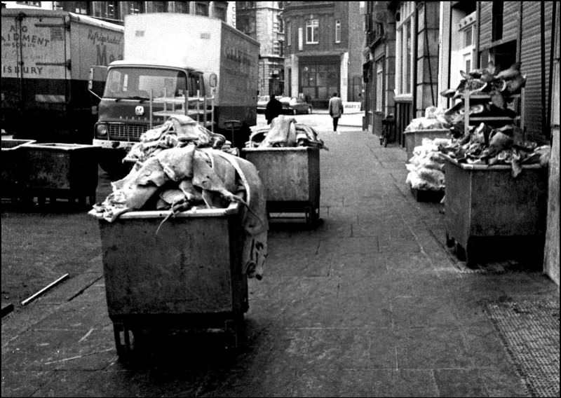 The remains of pig carcases, in skips ready for disposal, probably to the sausage factory, at the Smithfield meat market, London, March 1973