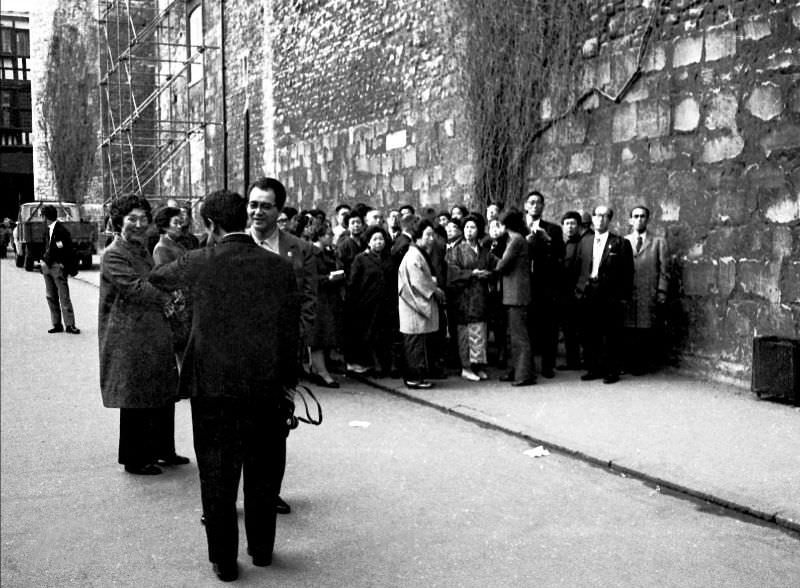 Party of Japanese tourists waits for a late coach, London, 1972