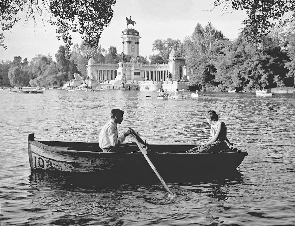 A couple row in a boat on the Retiro pond during the 1960s in Madrid, Spain.