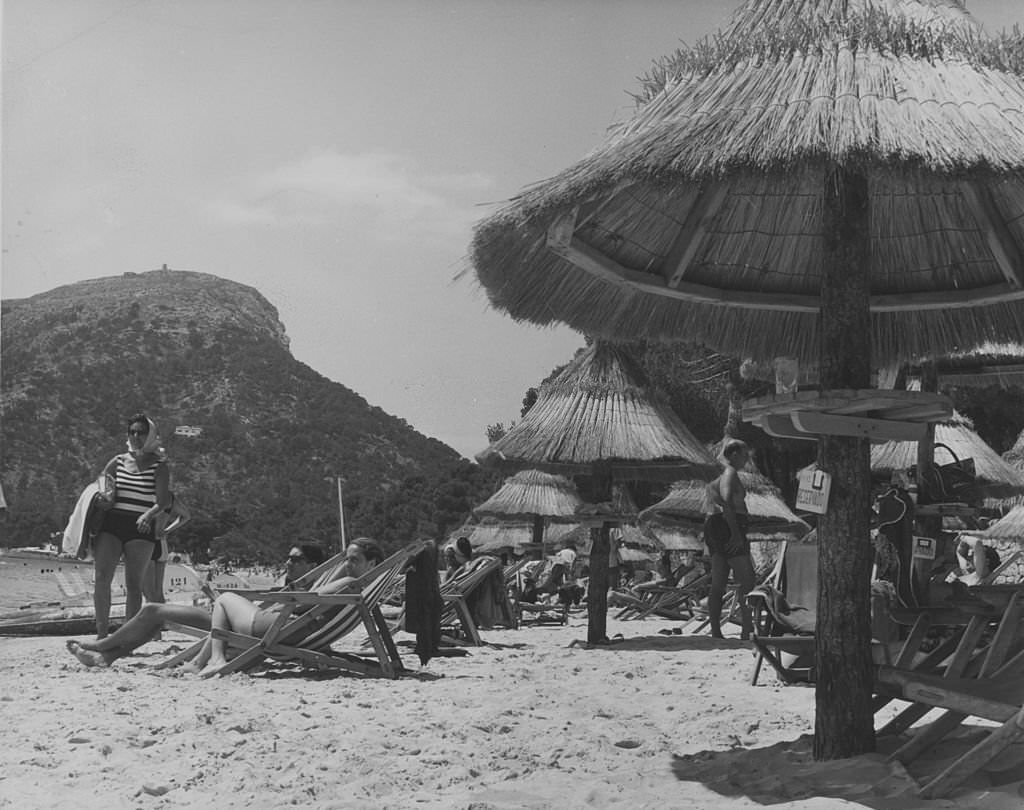 Straw beach umbrellas at Formentor beach in Majorca, Balearic Islands, 1955