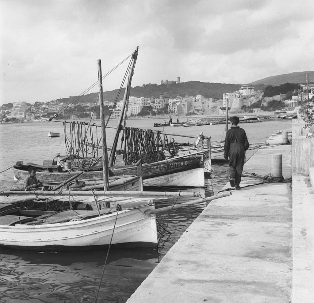 A group of small fishing boats in the foreground of Palma harbour on the island of Majorca, 1955