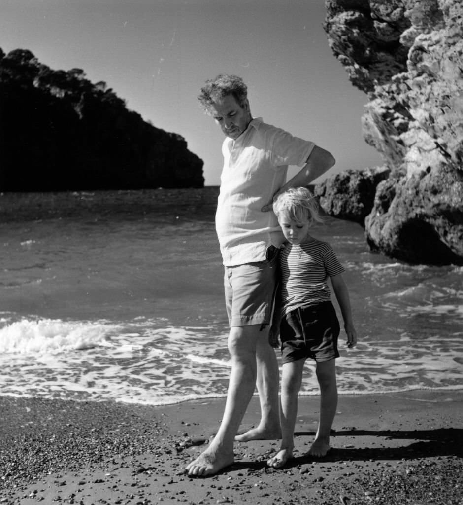 Robert Graves on the beach at Deya, Majorca, with his son Juan, 1954