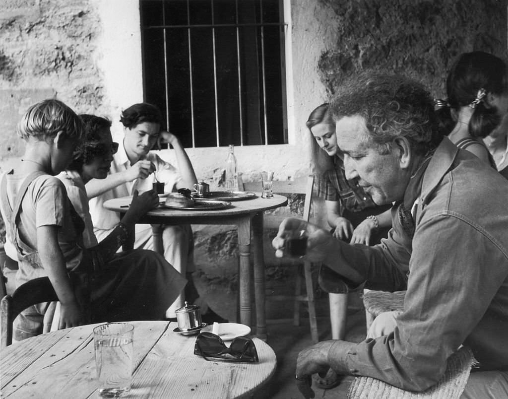 English poet, novelist, essayist and critic Robert Graves drinking at a cafe in Deya, Majorca, January 1954.
