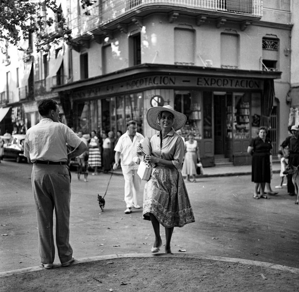 Actress and singer Abbe Lane walks through the streets of Mallorca accompanied by her husband Xavier Cugat and their dog.