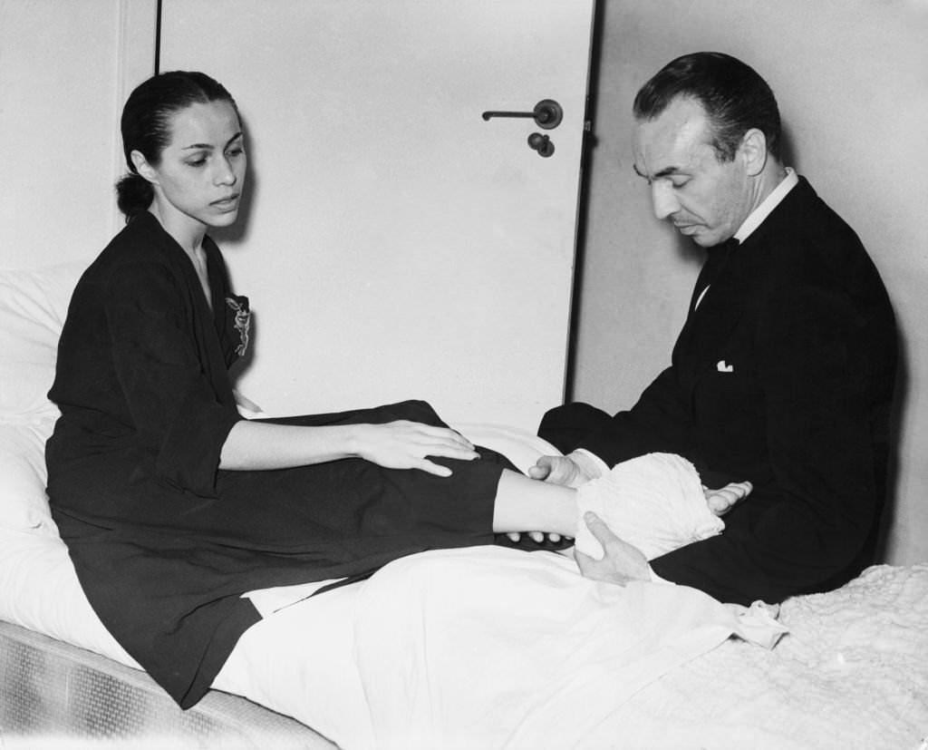 Maria Tallchief with her husband George Balanchine after she injured her ankle at the ballet's debut performance in Covent Garden the night before, 11th July 1950.