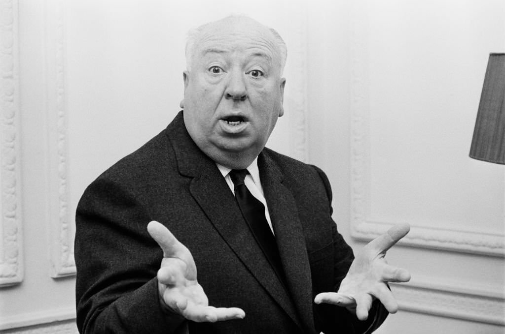 Alfred Hitchcock gestures with his hands towards the camera in November 1964.