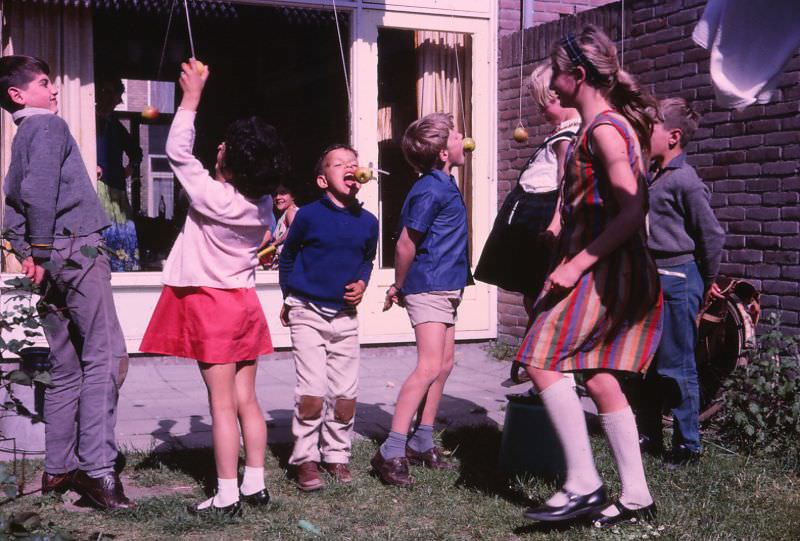 Kids play bobbing for apples, Woerden, Netherlands, 1966
