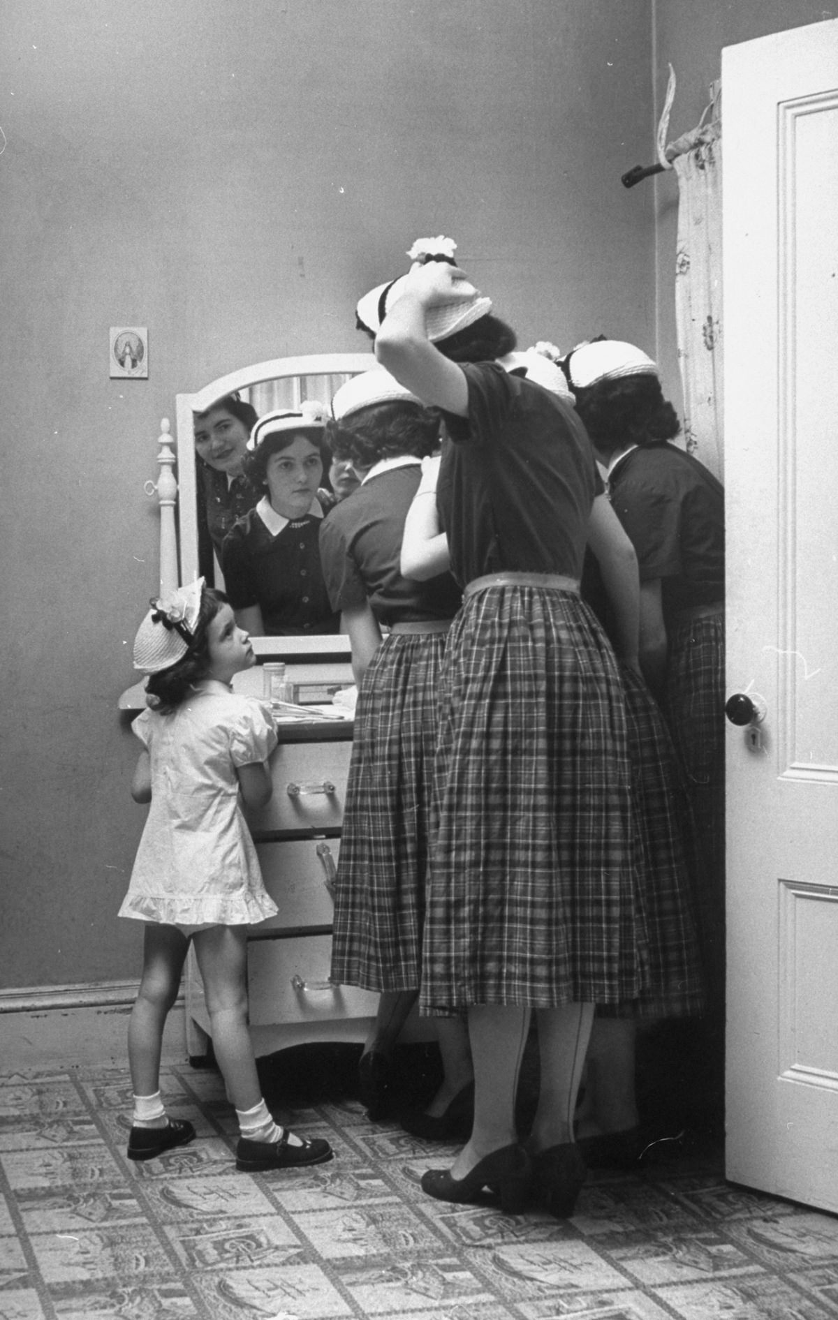 A little O’Neil admiring her four big sisters in their new Easter finery, 1952.