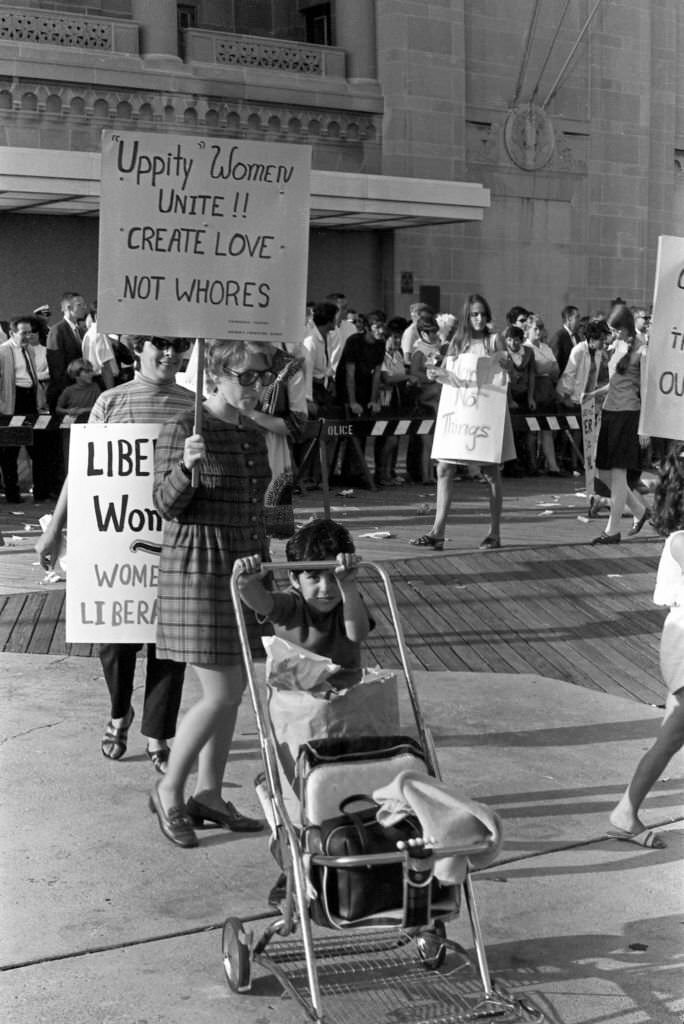 A demonstrator carries a poster that reads 'Uppity Women Unite!! Create Love, Not Whores' as, with others, she protests the Miss America beauty pageant, Atlantic City, 1968.
