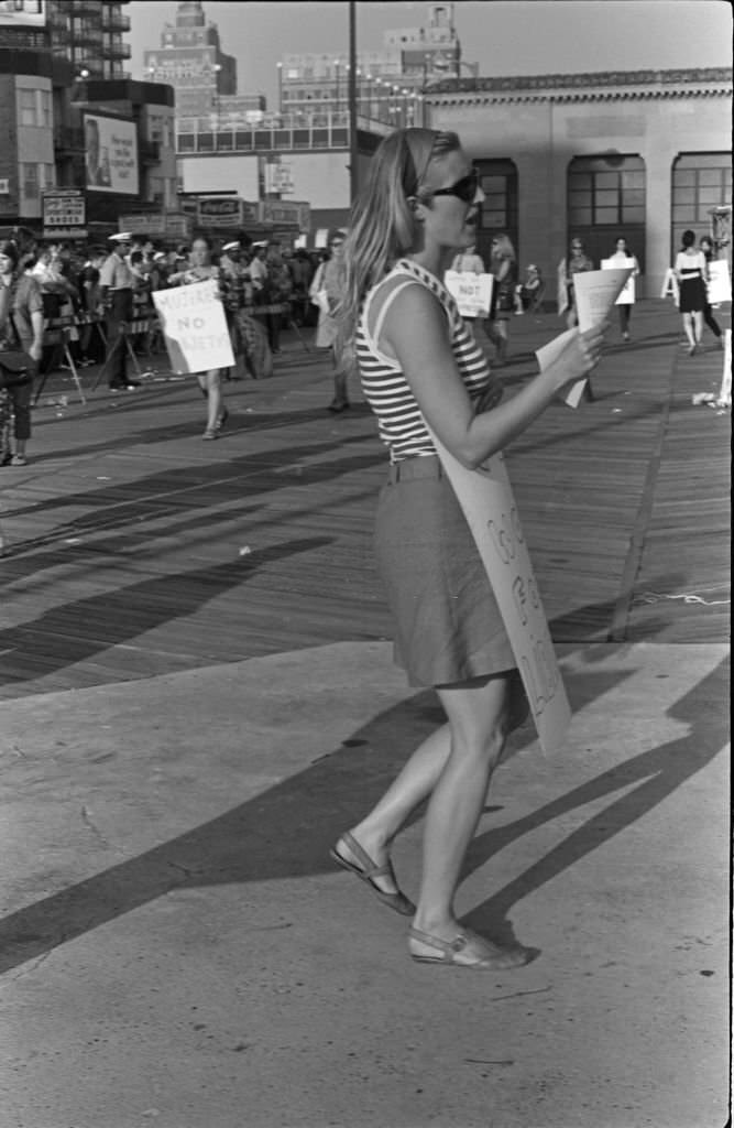 Demonstrator Peggy Dobbins, among others (many with posters) protest the Miss America beauty pageant, Atlantic City, New Jersey, September 7, 1968.