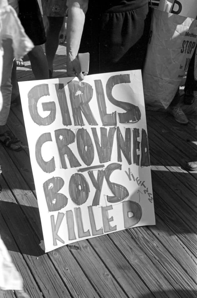 Poster that reads 'Girls Crowned, Boys Killed (Vietnam),' held by a demonstrator on the Atlantic City Boardwalk during a protest against the Miss America beauty pageant.