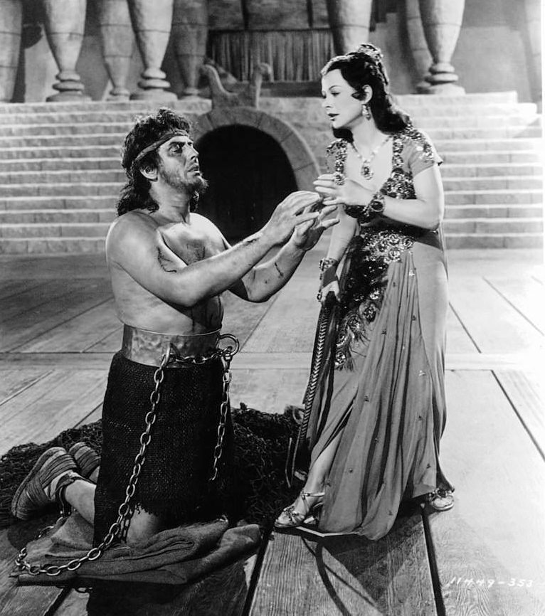 A shackled Victor Mature reaches up towards Hedy Lamarr in a scene from the film 'Samson And Delilah', 1949.