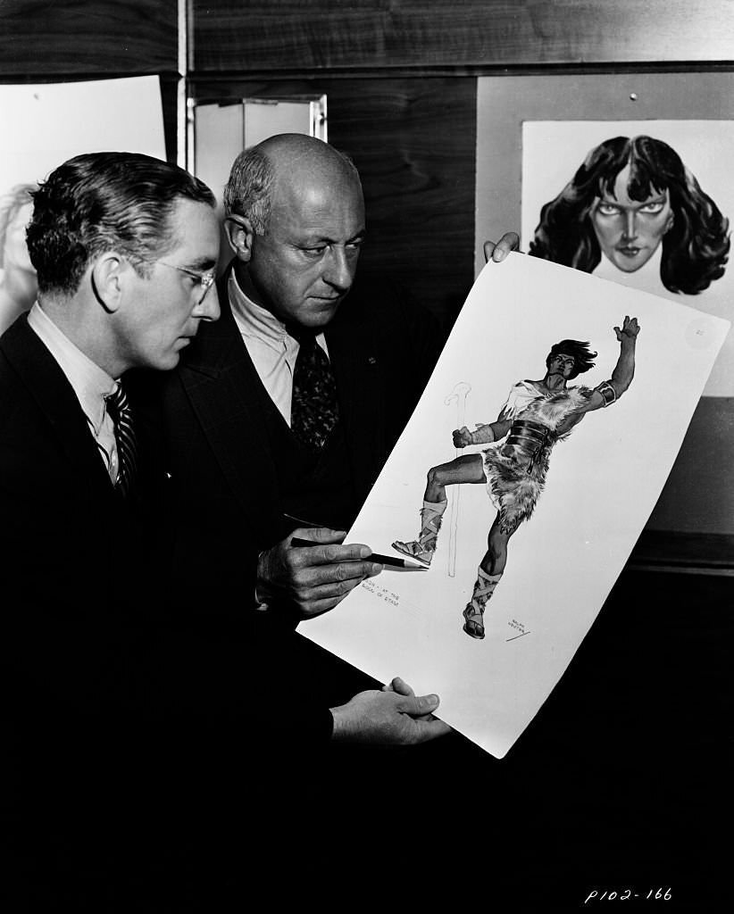 Filmmaker Cecil B DeMille inspecting costume design ideas for the film 'Samson and Delilah'